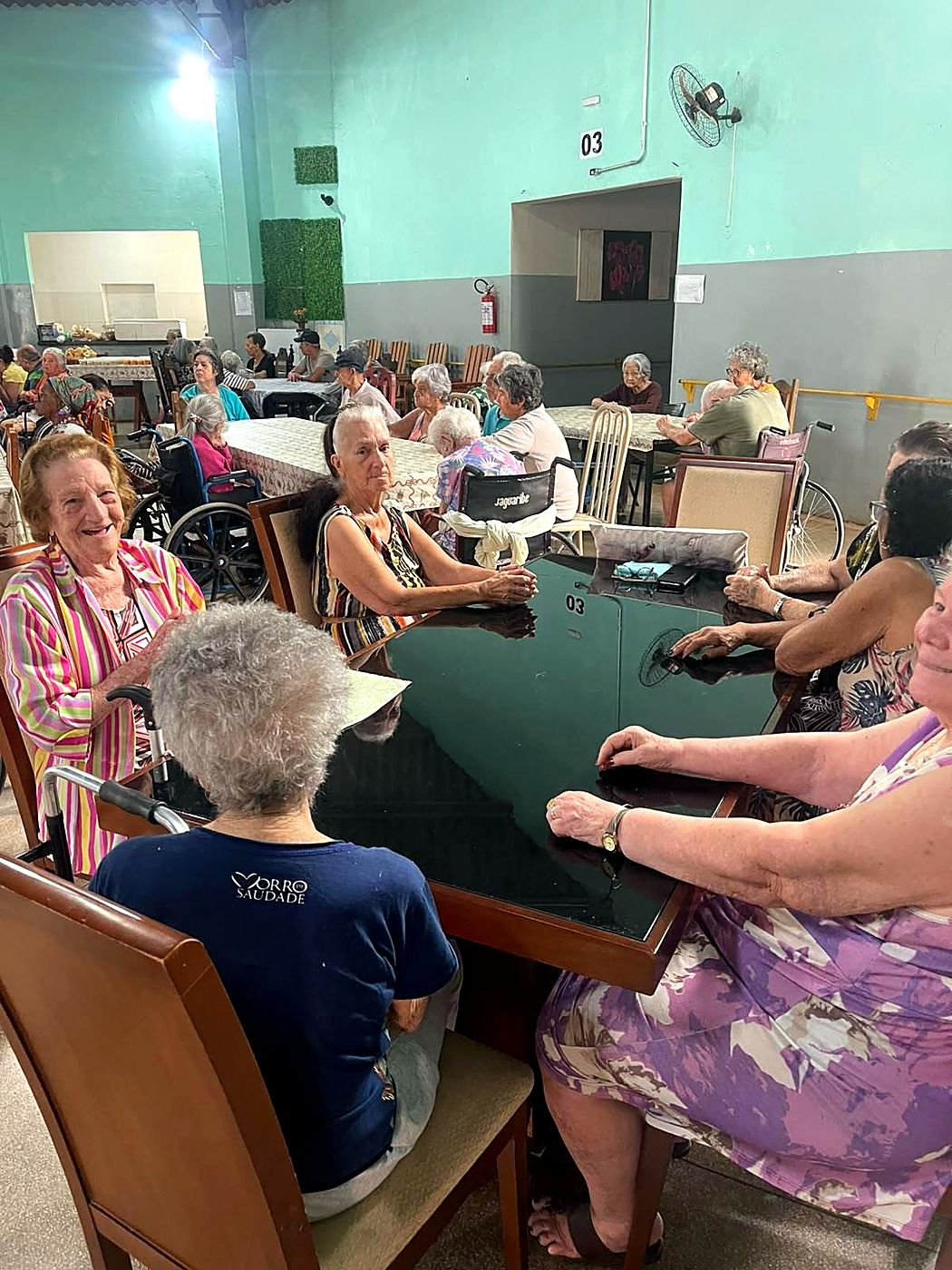 Idosas conversando e sorrindo à mesa no salão da Casa de Repouso Amor Infinito, em Ribeirão Preto