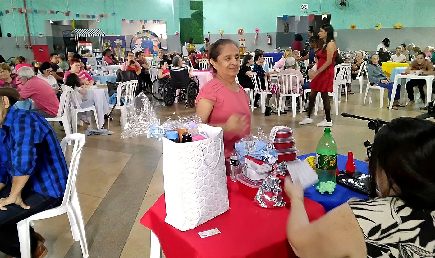 Festa junina com bingo, residentes e familiares no salão decorado